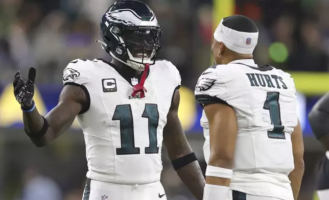 Philadelphia Eagles wide receiver A.J. Brown (11) celebrates with quarterback Jalen Hurts (1) during the second half of an NFL football game against the Los Angeles Rams in Inglewood, Calif., Sunday, Nov. 24, 2024. (AP Photo/Ryan Sun)