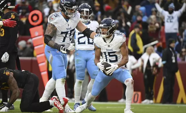 Tennessee Titans wide receiver Nick Westbrook-Ikhine (15) celebrates his touchdown with offensive tackle Dillon Radunz (75) during the second half of an NFL football game against the Washington Commanders, Sunday, Dec. 1, 2024, in Landover, Md. (AP Photo/Steve Ruark)