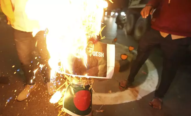 Activists of Bajarang dal, a Hindu rights group, burn an effigy of Bangladesh's interim leader Muhammad Yunus and a symbolic flag of Bangladesh, during a protest against the alleged attacks on Hindus in Bangladesh, in Ahmedabad, India, Wednesday, Dec. 11, 2024. (AP Photo/Ajit Solanki)