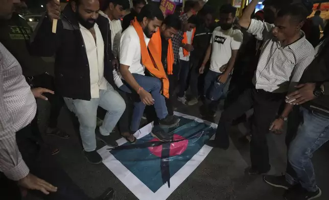 Activists of Bajarang dal, a Hindu rights group, step on a symbolic flag of Bangladesh, during a protest against the alleged attacks on Hindus in Bangladesh, in Ahmedabad, India, Wednesday, Dec. 11, 2024. (AP Photo/Ajit Solanki)