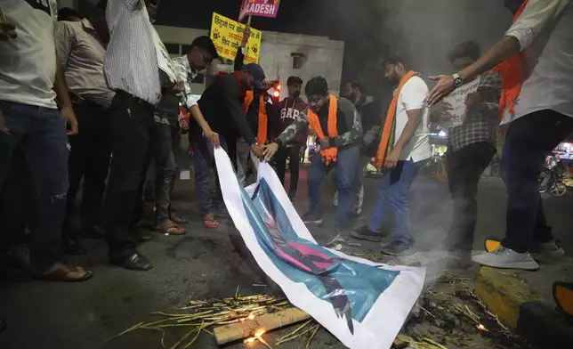 Activists of Bajarang dal, a Hindu rights group, burn an effigy of Bangladesh's interim leader Muhammad Yunus and a symbolic flag of Bangladesh, during a protest against the alleged attacks on Hindus in Bangladesh, in Ahmedabad, India, Wednesday, Dec. 11, 2024. (AP Photo/Ajit Solanki)