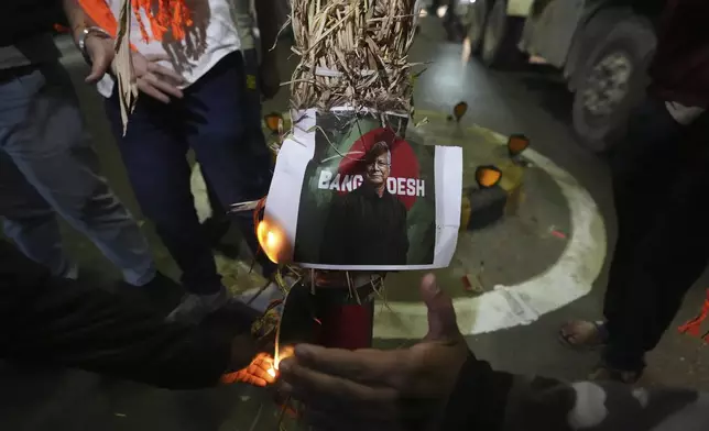 Activists of Bajarang dal, a Hindu rights group, burn an effigy of Bangladesh's interim leader Muhammad Yunus and a symbolic flag of Bangladesh, during a protest against the alleged attacks on Hindus in Bangladesh, in Ahmedabad, India, Wednesday, Dec. 11, 2024. (AP Photo/Ajit Solanki)