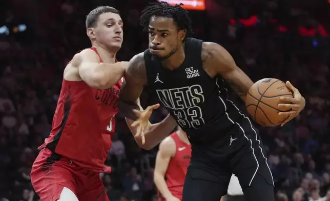 Brooklyn Nets center Nic Claxton (33) drives to the basket as Miami Heat forward Nikola Jovic, left, defends during the first half of an NBA basketball game, Monday, Dec. 23, 2024, in Miami. (AP Photo/Lynne Sladky)