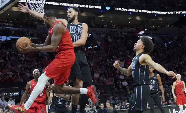 Miami Heat forward Haywood Highsmith, front left, looks to pass the ball as Brooklyn Nets guard Ben Simmons (10) defends during the second half of an NBA basketball game, Monday, Dec. 23, 2024, in Miami. (AP Photo/Lynne Sladky)