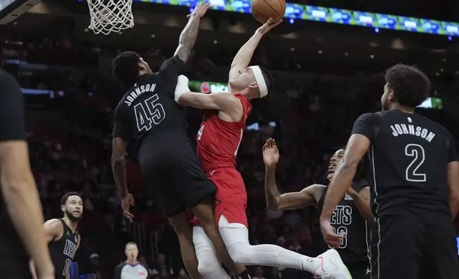 Miami Heat guard Tyler Herro, center right, goes to the basket as Brooklyn Nets guard Keon Johnson (45) defends during the second half of an NBA basketball game, Monday, Dec. 23, 2024, in Miami. (AP Photo/Lynne Sladky)