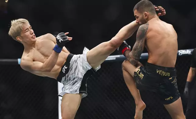 Kai Asakura, left, kicks Alexandre Pantoj in a UFC 310 mixed martial arts flyweight title bout at T-Mobile Arena, Saturday, Dec. 7, 2024, in Las Vegas. (Wade Vandervort/Las Vegas Sun via AP)