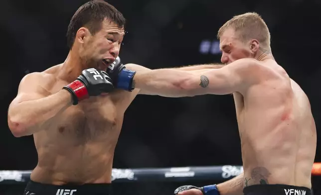 Shavkat Rakhmonov, right, punches Ian Machado Garry in a UFC 310 mixed martial arts welterweight bout at T-Mobile Arena, Saturday, Dec. 7, 2024, in Las Vegas. (Wade Vandervort/Las Vegas Sun via AP)