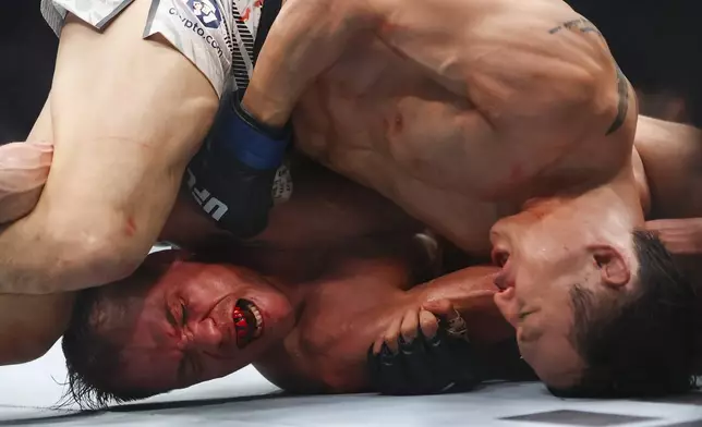 Dooho Choi, right, punches Nate Landwehr, left, in a UFC 310 mixed martial arts featherweight bout at T-Mobile Arena, Saturday, Dec. 7, 2024, in Las Vegas. (Wade Vandervort/Las Vegas Sun via AP)