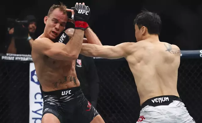 Dooho Choi, right, punches Nate Landwehr, left, in a UFC 310 mixed martial arts featherweight bout at T-Mobile Arena, Saturday, Dec. 7, 2024, in Las Vegas. (Wade Vandervort/Las Vegas Sun via AP)