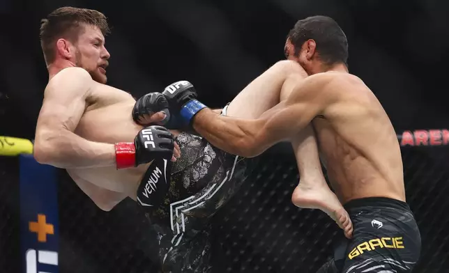 Bryce Mitchell, left, knees Kron Gracie, right, in a UFC 310 mixed martial arts featherweight bout at T-Mobile Arena, Saturday, Dec. 7, 2024, in Las Vegas. (Wade Vandervort/Las Vegas Sun via AP)
