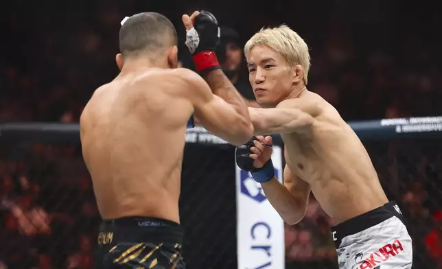 Kai Asakura, right, punches Alexandre Pantoja in a UFC 310 mixed martial arts flyweight title bout at T-Mobile Arena, Saturday, Dec. 7, 2024, in Las Vegas. (Wade Vandervort/Las Vegas Sun via AP)
