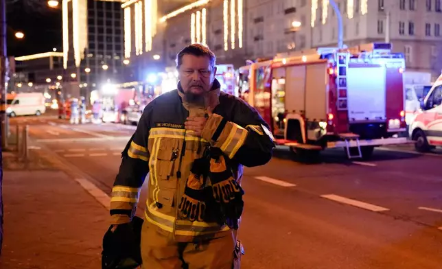 A firefighter walks through a cordoned-off area near a Christmas Market, after a car drove into a crowd in Magdeburg, Germany, Saturday, Dec. 21, 2024. (AP Photo/Ebrahim Noroozi)