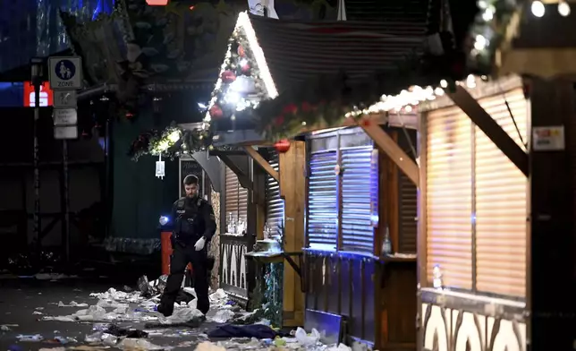 A policeman is seen at the Christmas market where an incident happened in Magdeburg, Germany, Friday Dec. 20, 2024. (Heiko Rebsch/dpa via AP)