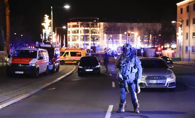 Police officers guard at a blocked road near a Christmas market after an incident in Magdeburg, Germany, Friday, Dec. 20, 2024. (AP Photo/Ebrahim Noroozi)