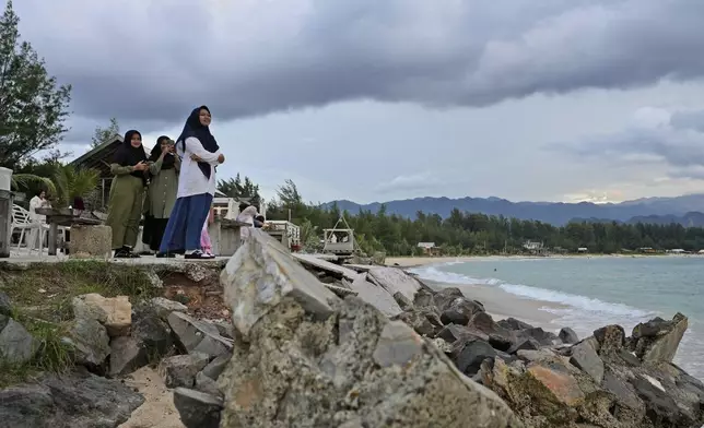 Young girls enjoy the view at Lampuuk beach, one of the areas hardest hit by Indian Ocean tsunami in 2004, on the outskirts of Banda Aceh, Indonesia, Friday, Dec. 13, 2024. (AP Photo/Achmad Ibrahim)