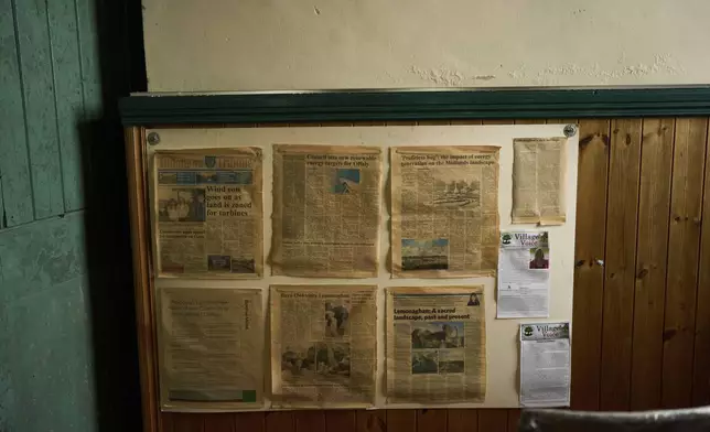 Old local newspapers are hanging on a wall inside an activist head quarters, in Lemanaghan, Ireland, Wednesday, Oct. 16, 2024, who oppose to the construction of wind farms. (AP Photo/Bram Janssen)