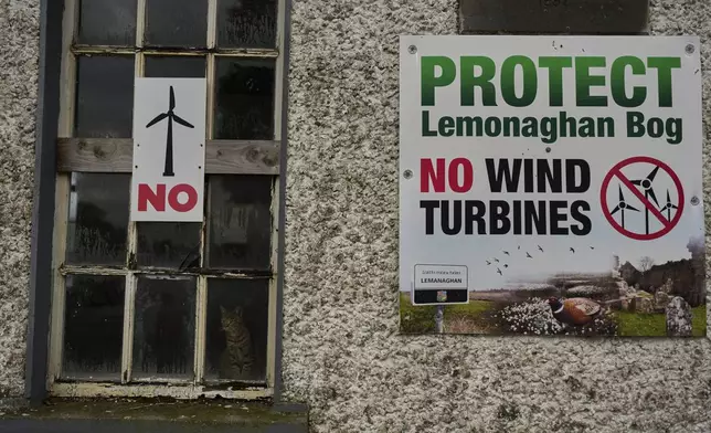 Protest banners against wind turbines displayed on a building in Lemanaghan, Ireland, Wednesday, Oct. 16, 2024. (AP Photo/Bram Janssen)