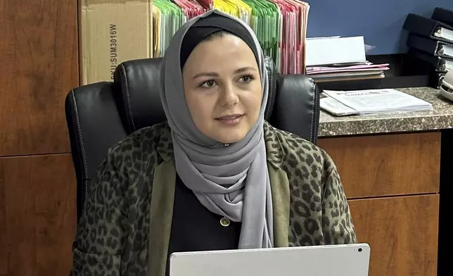 Rama Alhoussaini sits at her desk in Dearborn Heights, Mich., Tuesday, Dec. 10, 2024. (AP Photo/Corey Williams)