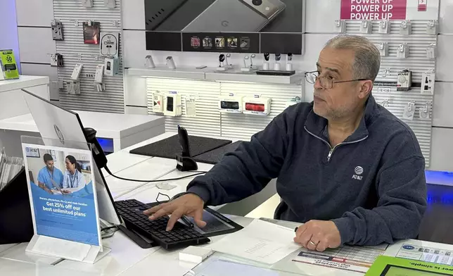 Nizam Abazid sits in his cellular shop in Dearborn, Mich., Tuesday, Dec. 10, 2024. Abazid, 59, left Syria in 1984. (AP Photo/Corey Williams)