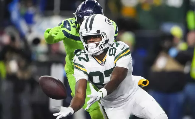 Green Bay Packers' Romeo Doubs catches a touchdown pass in front of Seattle Seahawks' Devon Witherspoon during the second half of an NFL football game Sunday, Dec. 15, 2024, in Seattle. (AP Photo/Lindsey Wasson)