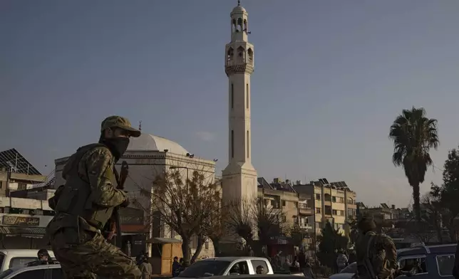 A member of the security forces of the newly formed Syrian government patrols an area near to a security checkpoint in Homs, Syria, Thursday, Dec. 26, 2024. (AP Photo/Leo Correa)