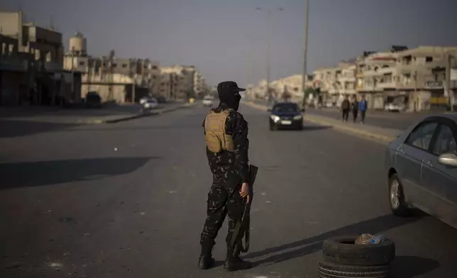 A member of the security forces of the newly formed Syrian government stands on guard at a security checkpoint in Homs, Syria, Thursday, Dec. 26, 2024. (AP Photo/Leo Correa)