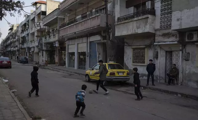 Boys play soccer on a street in an Alawite neighbourhood, in Homs, Syria, Thursday, Dec. 26, 2024. (AP Photo/Leo Correa)