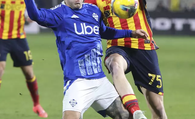 Como's Gabriel Strefezza, left, and Lecce's Balthazar Pierret in action during the Serie A soccer match between Como and Lecce at the Giuseppe Sinigaglia stadium in Como, Italy, Monday Dec. 30, 2024. (Antonio Saia/LaPresse via AP)