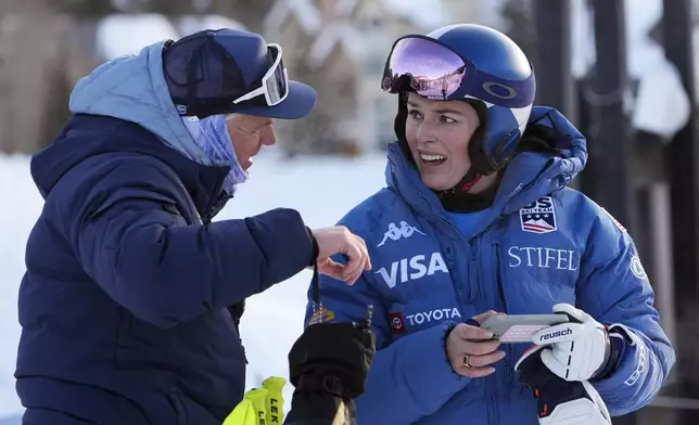 Lindsey Vonn talks with a coach after competing in a Super G skiing race at Copper Mountain Ski Resort, Sunday, Dec. 8, 2024, in Copper Mountain, Colo. (AP Photo/Robert F. Bukaty)