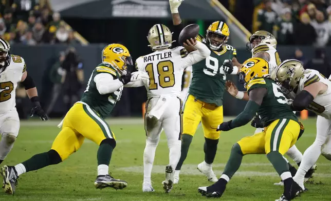 New Orleans Saints quarterback Spencer Rattler (18) passes under pressure during the second half of an NFL football game against the Green Bay Packers, Monday, Dec. 23, 2024, in Green Bay, Wis. (AP Photo/Mike Roemer)