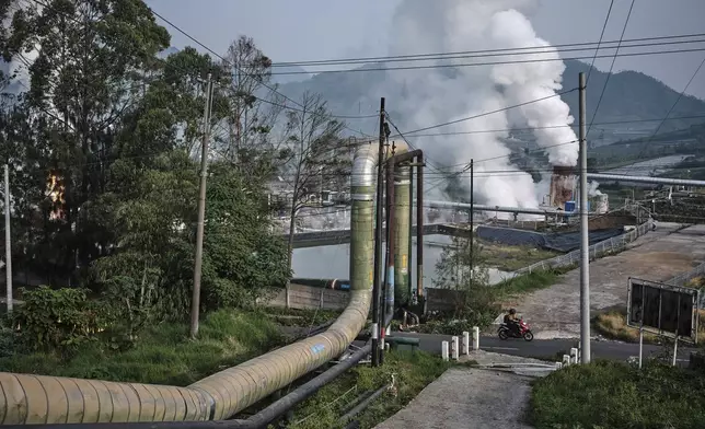 A motorist rides past a geothermal power plant in Dieng, Central Java, Indonesia, Nov. 15, 2024. (AP Photo/Beawiharta)