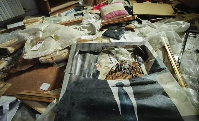 A broken portrait of the late Syrian President Hafez Assad lies on the floor as people search for belongings in the ransacked private residence of Syrian President Bashar Assad in the Malkeh district of Damascus, Syria, on Sunday, Dec. 8, 2024. (AP Photo/Hussein Malla)