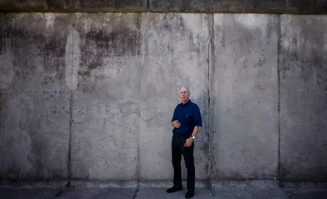 FILE -In this Sept. 4, 2019 photo, Frieder Reimold the former Berlin bureau chief of The Associated Press' German service poses for a photo in front of a part of the Berlin Wall during an interview with the Associated Press at the Berlin Wall Memorial side in Berlin, Germany. (AP Photo/Markus Schreiber, File)