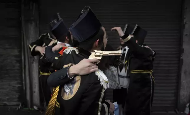 Jewish ultra-Orthodox men dressed in costumes celebrate the Jewish festival of Purim in Bnei Brak, Israel, on March 24, 2024. The holiday commemorates the Jews' salvation from genocide in ancient Persia, as recounted in the Book of Esther. (AP Photo/Oded Balilty)