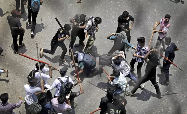 Students beat a policeman with sticks during a protest over a controversial quota system for government job applicants in Dhaka, Bangladesh, on July 18, 2024. (AP Photo/Anik Rahman)