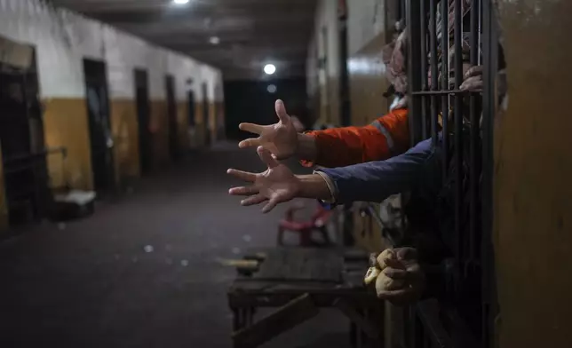 Prisoners reach out from their cell for bread at lunchtime at the Juan de la Vega prison in Emboscada, Paraguay, on July 12, 2024. (AP Photo/Rodrigo Abd)