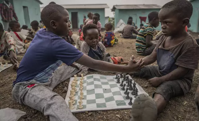 Children shake hands before they play a chess game at The Soga Chess Club of the internally displaced persons camp in Kanyaruchinya, Democratic Republic of Congo, on July 29, 2024. (AP Photo/Moses Sawasawa)