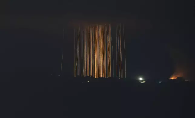 In this photo taken with a long exposure, Israeli shelling hits an area in southern Lebanon, as seen from northern Israel, on Sept. 30, 2024. (AP Photo/Leo Correa)