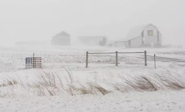 An American flag is mounted on a fence at a farm on U.S. Highway 20 during a blizzard near Galva, Iowa, on Jan. 13, 2024. (AP Photo/Carolyn Kaster)