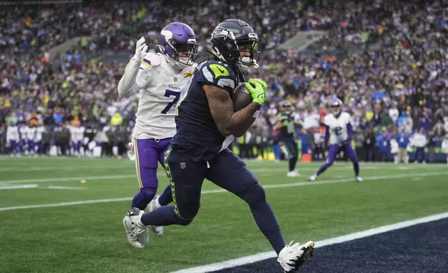 Seattle Seahawks wide receiver Jaxon Smith-Njigba (11) scores an 18-yard touchdown ahead of Minnesota Vikings cornerback Byron Murphy Jr. (7) during the first half of an NFL football game, Sunday, Dec. 22, 2024, in Seattle. (AP Photo/Lindsey Wasson)