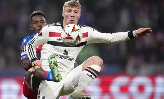 Manchester United's Rasmus Hojlund, right, challenges for the ball with Plzen's Sampson Dweh during the Europa League soccer match between Viktoria Plzen and Manchester United at the Doosan Arena in Plzen, Czech Republic, Thursday, Dec. 12, 2024. (AP Photo/Petr David Josek)