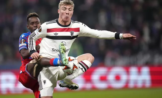 Manchester United's Rasmus Hojlund, right, challenges for the ball with Plzen's Sampson Dweh during the Europa League soccer match between Viktoria Plzen and Manchester United at the Doosan Arena in Plzen, Czech Republic, Thursday, Dec. 12, 2024. (AP Photo/Petr David Josek)