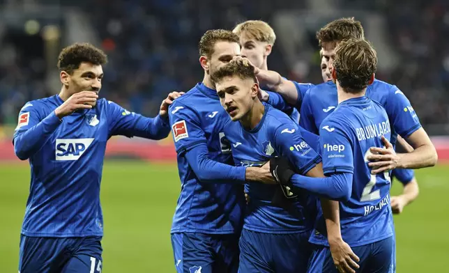 Hoffenheim's Tom Bischof, third from left, celebrates with teammates after scoring during the German Bundesliga soccer match between TSG 1899 Hoffenheim and SC Freiburg at the PreZero Arena, in Sinsheim, Germany, Sunday, Dec. 8, 2024. (Uwe Anspach/dpa via AP)