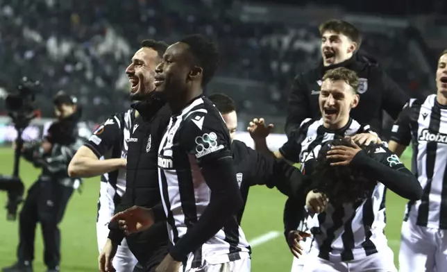 PAOK players celebrate their win against Ferencvaros after the end of the Europa League opening phase soccer match between PAOK and Ferencvaros at Toumpa stadium, in Thessaloniki, Greece, Thursday, Dec. 12, 2024. (AP Photo/Giannis Papanikos)