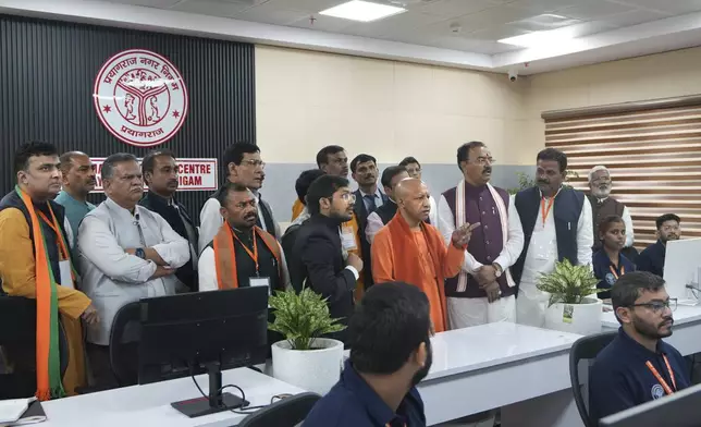 Uttar Pradesh chief minister Yogi Adityanath, center, in saffron robe, inspects a control center of the municipal corporation in preparation for the upcoming Maha Kumbh Mela, one of the world's largest religious festivals, in Prayagraj, India, Wednesday, Nov. 27, 2024. (AP Photo/Rajesh Kumar Singh)