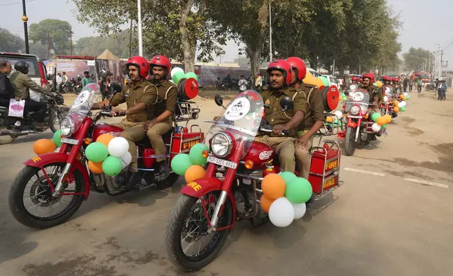 Firefighters on motorcycles decorated with balloons ride through the town in a public relations exercise before the upcoming Maha Kumbh Mela, one of the world's largest religious festivals, in Prayagraj, India, Wednesday, Nov. 27, 2024. (AP Photo/Rajesh Kumar Singh)