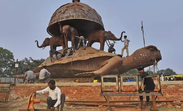 Workers build a mural in preparation for the upcoming Maha Kumbh Mela, one of the world's largest religious festivals, in Prayagraj, India, Saturday, Nov. 30, 2024. (AP Photo/Rajesh Kumar Singh)