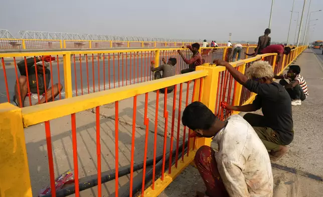 Workers paint the railings of a bridge over the Ganges river, in preparation for the upcoming Maha Kumbh Mela, one of the world's largest religious festivals, in Prayagraj, India, Tuesday, Nov. 26, 2024. (AP Photo/Rajesh Kumar Singh)