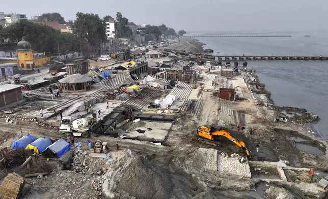 An earthmover works on the banks of the Ganges river preparing the site for the upcoming Maha Kumbh Mela, one of the world's largest religious festivals, in Prayagraj, India, Friday, Nov. 22, 2024. (AP Photo/Rajesh Kumar Singh)