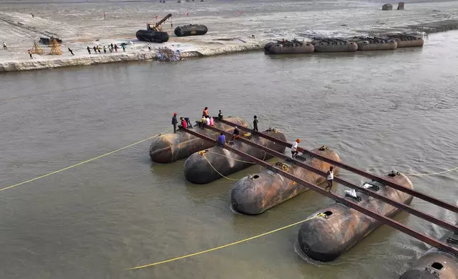 Workers build a pontoon bridge over the Ganges river in preparation for the upcoming Maha Kumbh Mela, one of the world's largest religious festivals, in Prayagraj, India, Monday, Nov. 25, 2024. (AP Photo/Rajesh Kumar Singh)